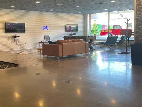 Modern lounge area with gaming consoles and sofas.