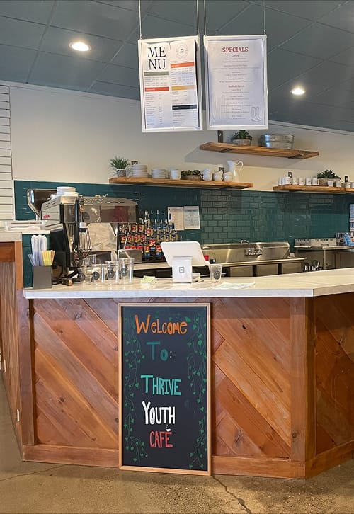 Thrive Youth Café interior with menu and counter.