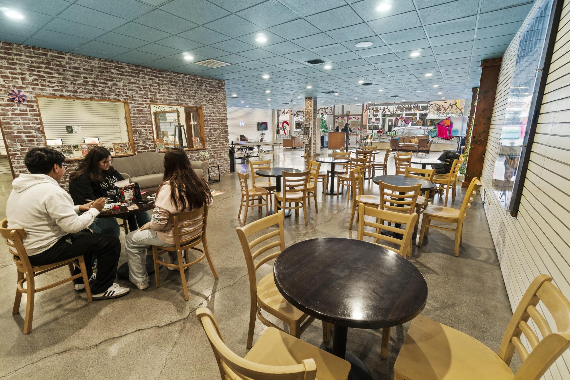 People playing cards in cozy cafe setting.