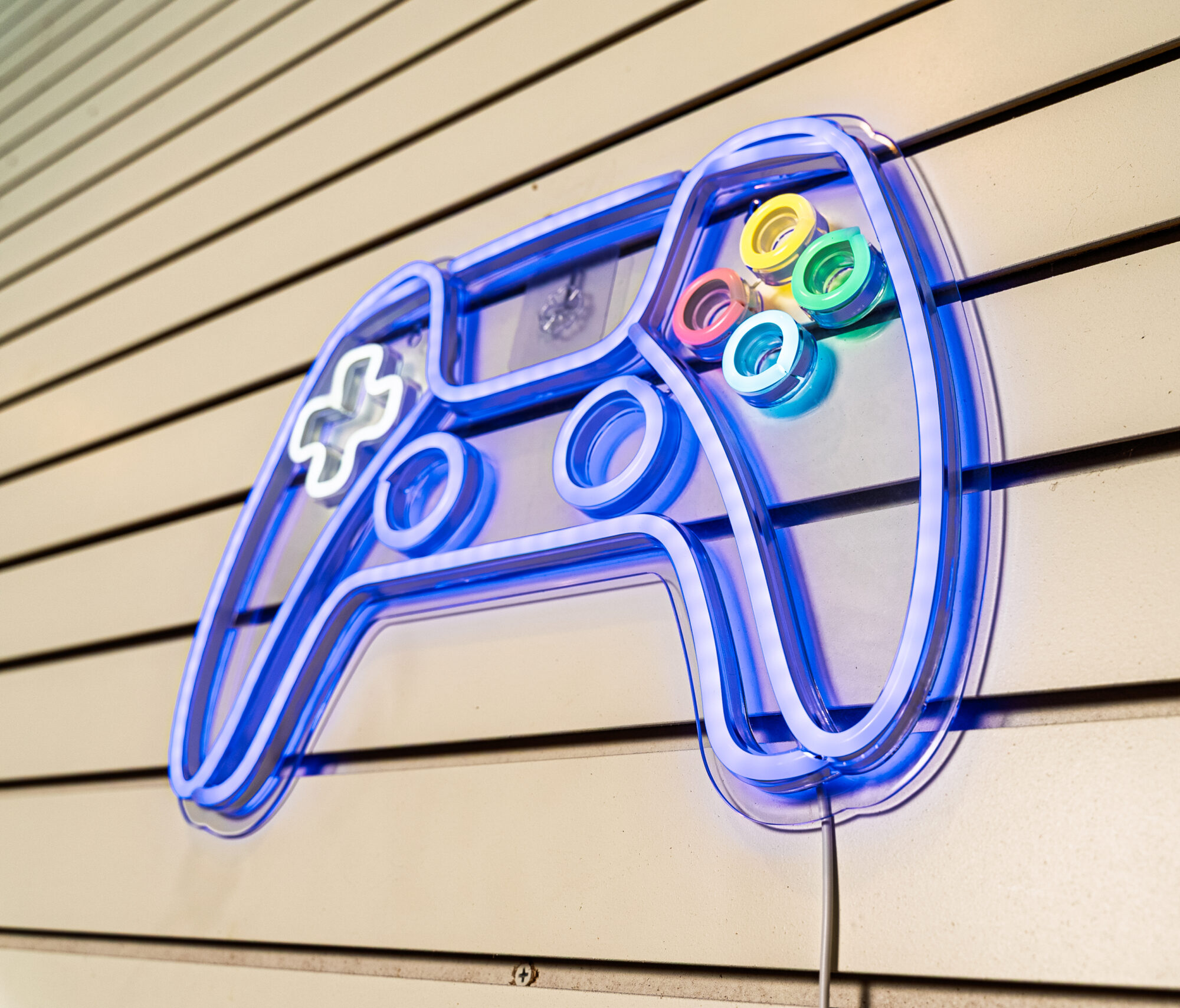 Neon gaming controller on wall display.