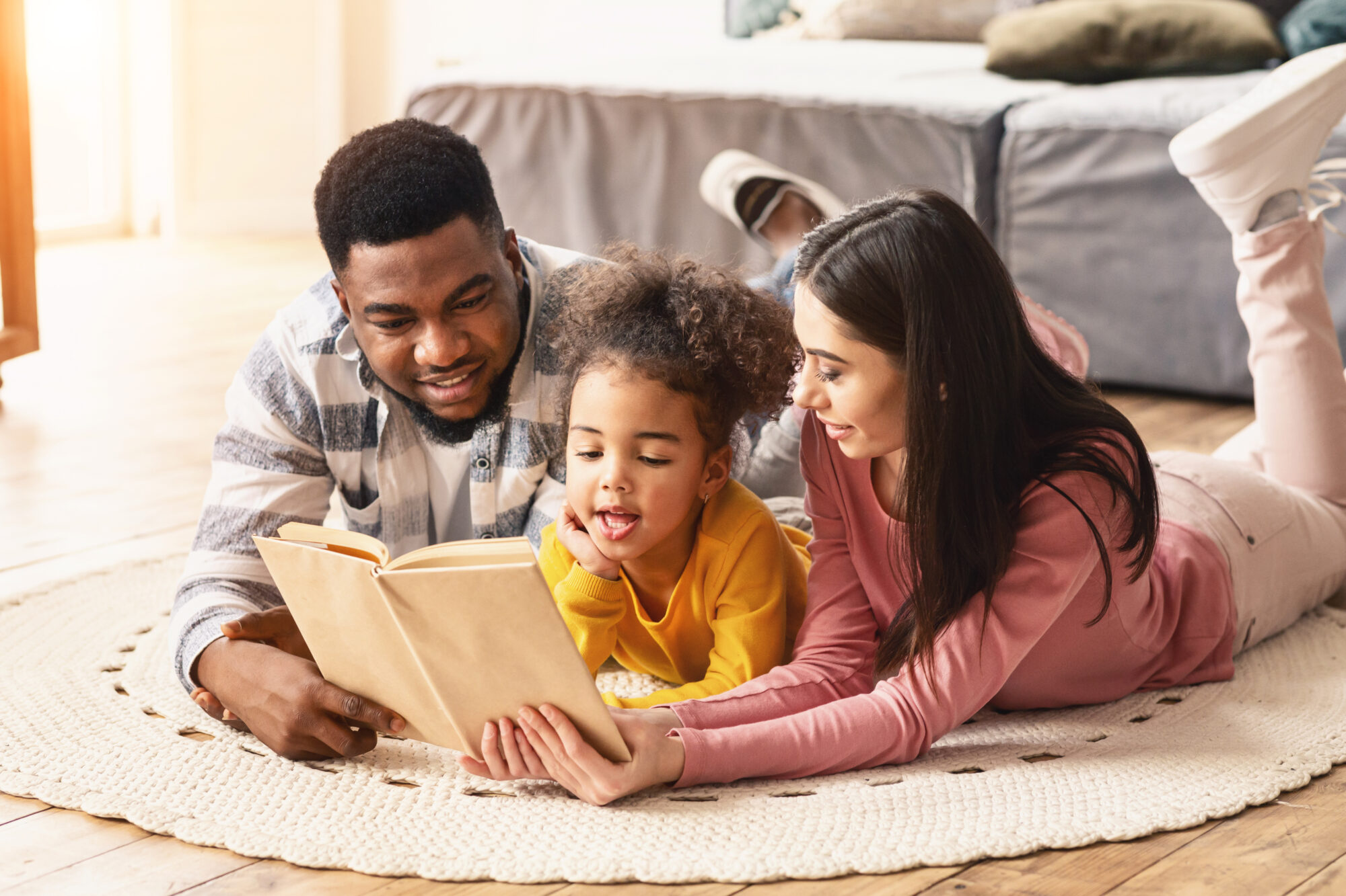 Family reading together on cozy floor mat.